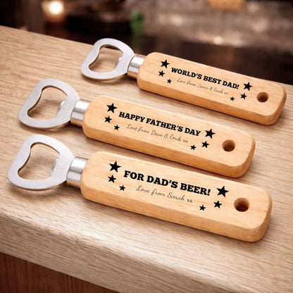 Three wooden bottle openers with personalized messages on them, placed on a wooden surface.