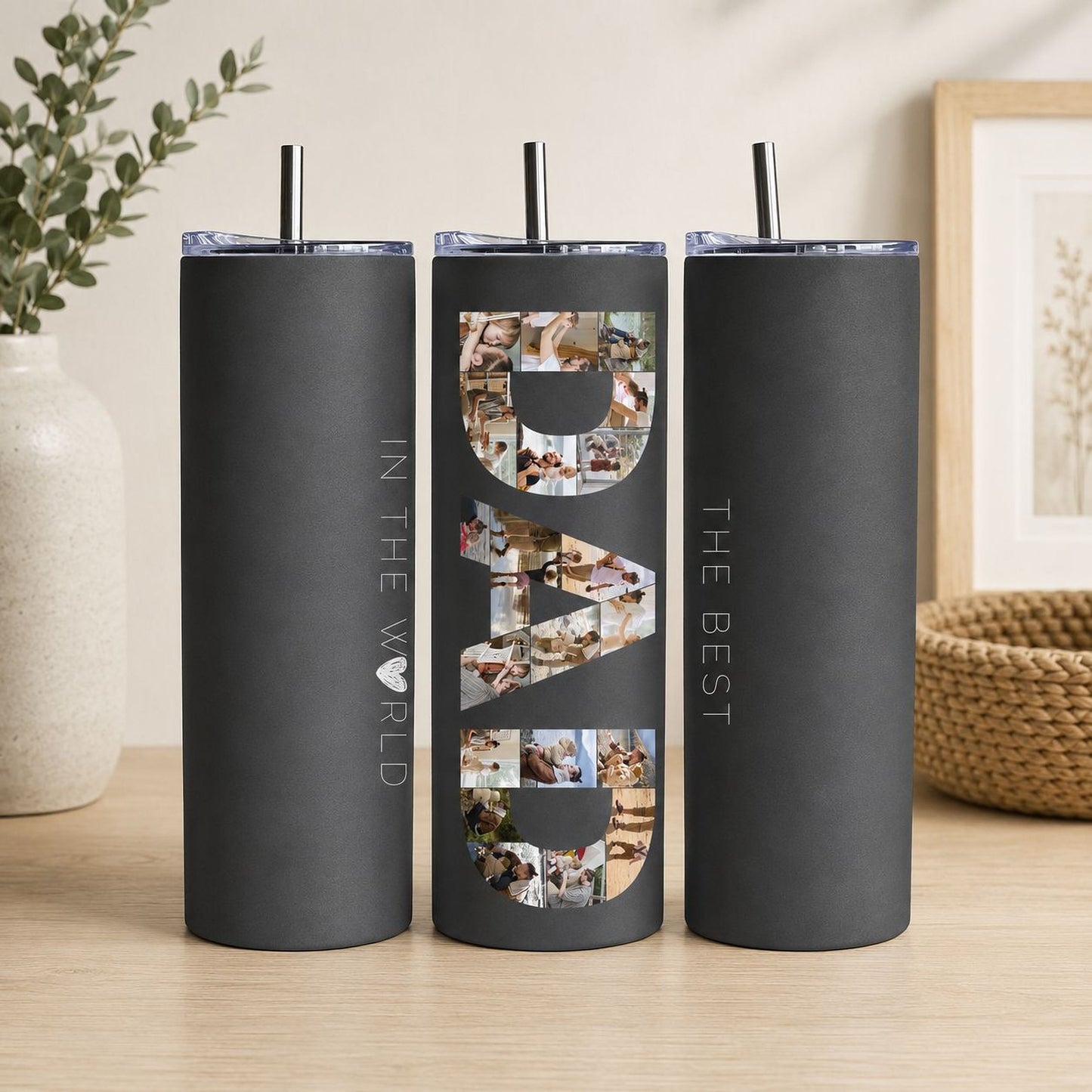 A black tumblers with the word "DAD" printed on them, along with a straw.