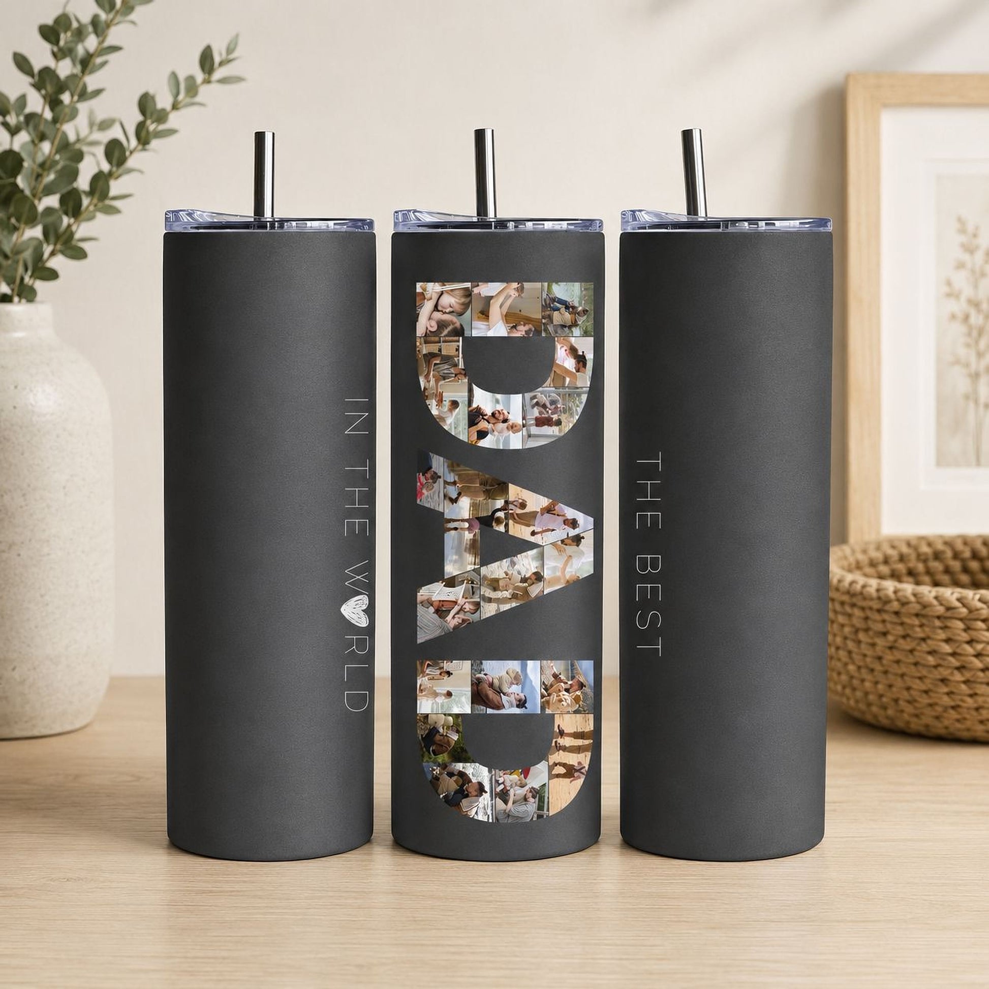 A black tumblers with the word "DAD" printed on them, along with a straw.