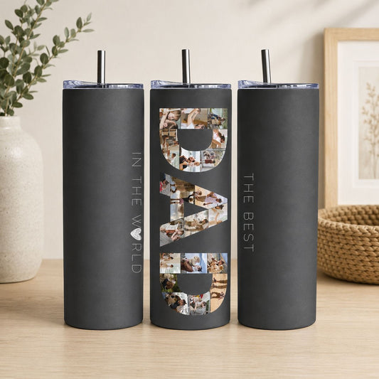 A black tumblers with the word "DAD" printed on them, along with a straw.