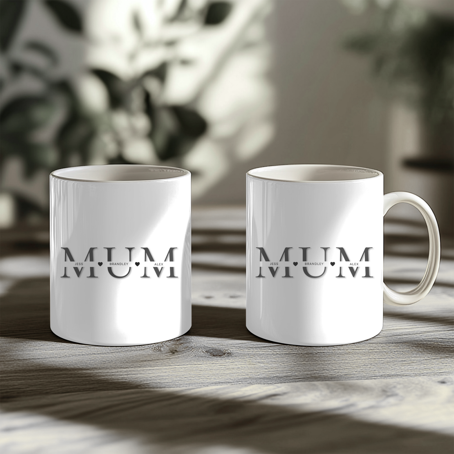White mugs with the word "MUM" printed on them, placed on a wooden surface.